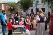 De vrouwen in historische dracht praten naast de hut van jute