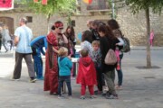 De volwassenen helpen de kinderen de turquoise mantels aan te trekken