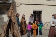 De kinderen passen kleurige mantels op een bank in Bailo