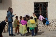 De jonge vrouw brengt de kinderen naar de volgende activiteit in de tent