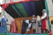 De kinderen delen snoep op het plein terwijl de voorstelling doorgaat