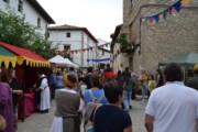 I cavalieri si allontanano per una via verso il mercato medievale
