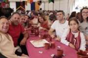 Abitanti e visitatori condividono il pranzo popolare ai tavoli del tendone
