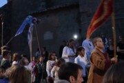 Di notte, bambini in costume si riuniscono accanto al muro della chiesa