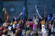 Bambini e adulti agitano stendardi accanto al muro della chiesa