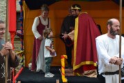 Un bambino si avvicina al re sotto il baldacchino arancione per una benedizione