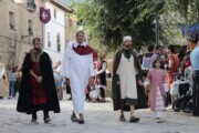 Figuranti ecclesiastici e cortigiani camminano verso la chiesa con il corteo
