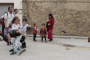 Bambini in costume giocano con un oggetto di legno a un banco di giochi