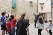 Un anziano in costume invita i bambini a giocare nella piazzetta