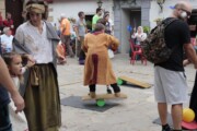Un bambino si esercita in equilibrio su una tavola con le ruote accanto al muro