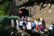 Abitanti e visitatori varcano il portale a volta della chiesa