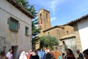 Abitanti con le pertiche si riuniscono davanti alla torre addobbata di Bailo