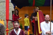 Una giovane con il surcotto della croce salta sopra i tronchi sul sentiero