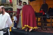 Il re si inchina davanti a una bambina, la dama regge la corona
