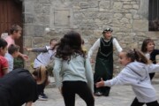 Un'animatrice in costume gioca in girotondo con i bambini a Bailo