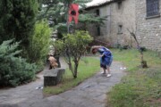 Due giovani in tunica corrono fra gli alberi del giardino di Bailo