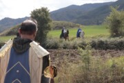 In lontananza, due cavalieri cavalcano fra i campi con i Pirenei aragonesi