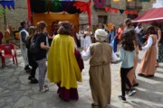 Un gruppo di ballerini danza in girotondo incoraggiato dai musicisti