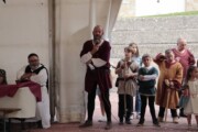 Un uomo con il microfono presenta un'attività per bambini sotto il tendone