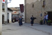 Una donna cammina accanto a un falconiere con il suo rapace