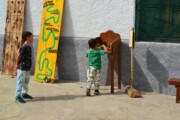 Due bambini giocano vicino a un pannello del Cammino di Santiago