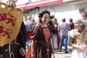 Una donna in abito medievale sfila accanto a un alfiere nobile