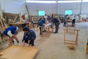 Alcuni volontari dipingono scudi in un laboratorio durante i preparativi