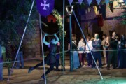 Un'acrobata esegue una coreografia con il cerchio luminoso nella piazza notturna