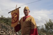 Un alfiere porta uno stendardo con la ruota sotto il cielo nuvoloso