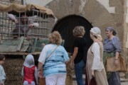Un uomo chiuso in una gabbia interpreta un prigioniero