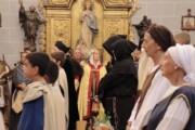 Un vescovo con la mitra presiede l'atto religioso davanti alla pala d'altare dorata