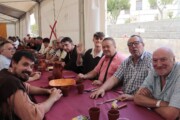 Un frate condivide la tavola con altri commensali sotto il tendone medievale