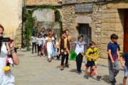 Alcuni bambini attraversano un arco di pietra coperto d'edera