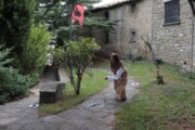 Una giovane gioca nel giardino cintato accanto alla Sede Reale