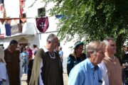 Alcuni figuranti camminano per la via principale accanto alla Sede Reale
