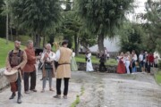 Alcuni musicisti ambulanti aprono la sfilata accanto al muro di pietra