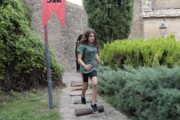 Una bambina corre sui tronchi lungo il sentiero verso la chiesa