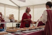 Una donna conversa a un tavolo di focacce e dolci artigianali
