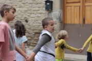 Bambini per mano camminano per una via selciata
