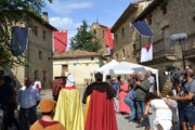 Due figure del corteo avanzano verso la torre della chiesa