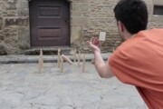 Un uomo gioca ai birilli di legno tradizionali a Bailo