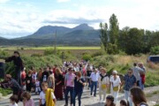 Una folla percorre una strada di campagna con i Pirenei aragonesi sullo sfondo