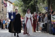 Una coppia di nobili rievocata cammina per una via selciata