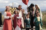 Una famiglia di rievocatori avanza lungo la via aragonese con il corteo