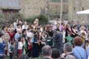 Abitanti e visitatori si riuniscono accanto a un muro di pietra
