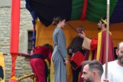 Una giovane regge una spada davanti al re durante un atto