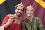 Il re e la regina posano sorridenti davanti a un fondale di studio