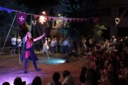 Un artista fa giochi di fuoco di notte in piazza