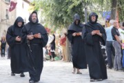 Quattro frati processionano lungo il Cammino di Santiago verso la chiesa