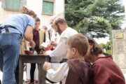Un artigiano mostra il suo mestiere ai bambini al mercato medievale